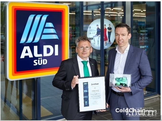 Erik Bucher BITZER 냉동부분 영업이사가 Jens Strassburg ALDI SÜD의 매장 운영관리 책임자에게 10만번째 CO2 왕복동 압축기 공급 증서를 수여하고 기념촬영하고 있다.
